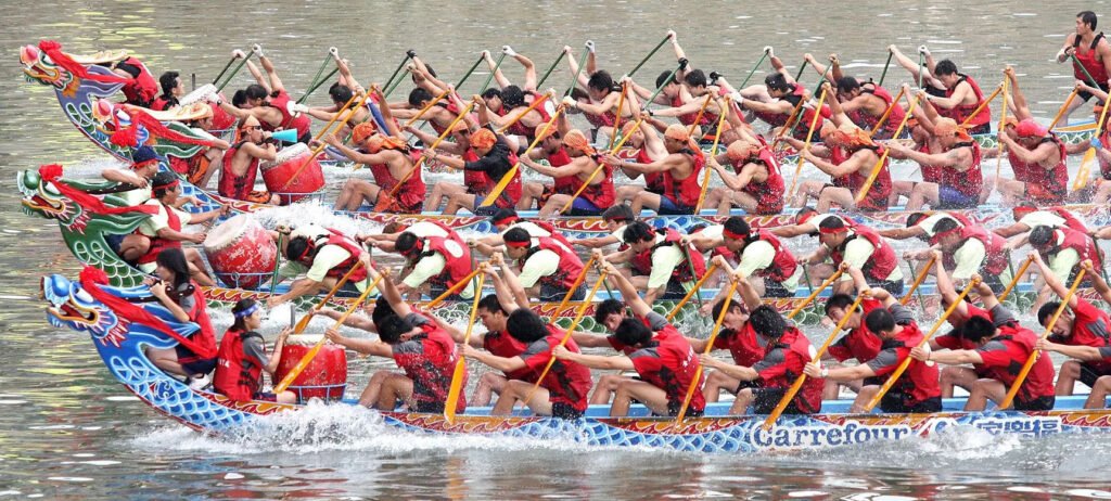 Esta imagen muestra una carrera de botes dragón, una tradición central del Festival del Bote del Dragón.