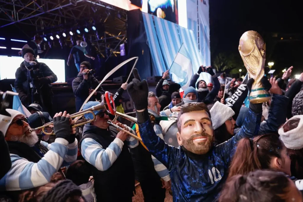Esta imagen muestra a aficionados celebrando la victoria de la selección argentina de fútbol en el Fan Fest de la Plaza Seeber en Palermo, Buenos Aires, durante el Mundial 2026.