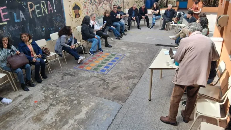 Esta imagen muestra un plenario de la Mesa de Cooperativas de CABA realizado en el patio de la Escuela Cooperativa Mundo Nuevo.