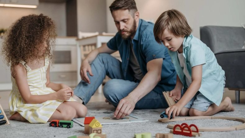 Imagen ilustrativa de padre con sus hijos jugando