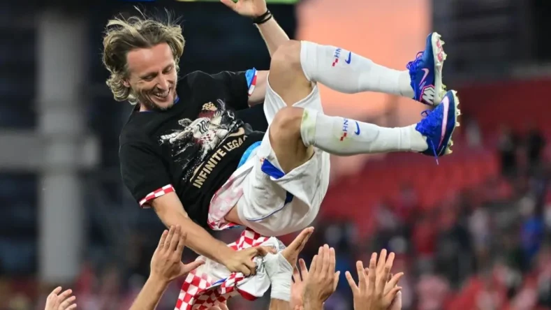 Esta imagen muestra a Luka Modrić siendo celebrado por sus compañeros tras alcanzar los 200 partidos internacionales con la selección de Croacia.