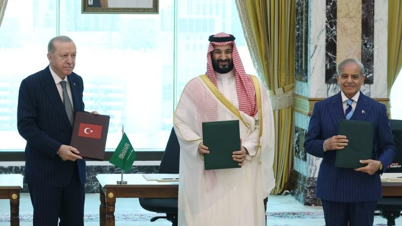 Esta imagen muestra al presidente turco Recep Tayyip Erdogan, al príncipe heredero de Arabia Saudita Mohammed bin Salman y al primer ministro paquistaní Shehbaz Sharif posando tras firmar un acuerdo conjunto de defensa en La Meca.
