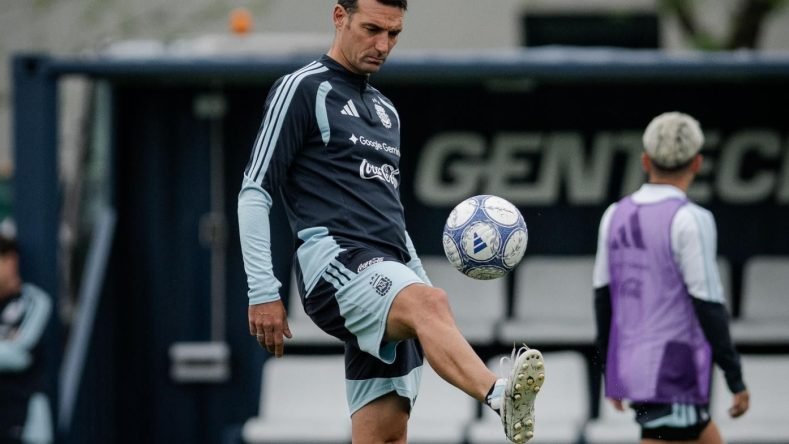 La imagen muestra al director técnico de la Selección Argentina, Lionel Scaloni, vistiendo indumentaria oficial de entrenamiento y dominando un balón en el predio de Ezeiza.