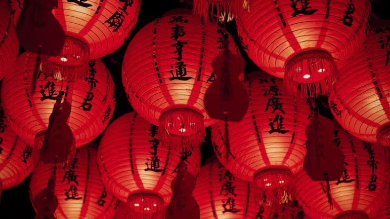 La imagen muestra un grupo de tradicionales faroles chinos rojos iluminados en la oscuridad.