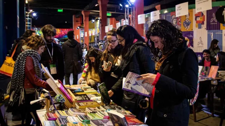Esta imagen muestra a varias personas explorando stands de libros en la Feria de Editores (FED) celebrada en el Complejo C Art Media de Buenos Aires.