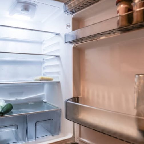Almost empty  fridge with open door Surrey England