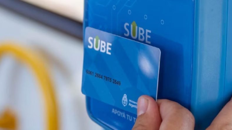 La imagen muestra una mano apoyando una tarjeta SUBE (Sistema Único de Boleto Electrónico) contra una validadora azul para abonar un viaje en el transporte público en Argentina.