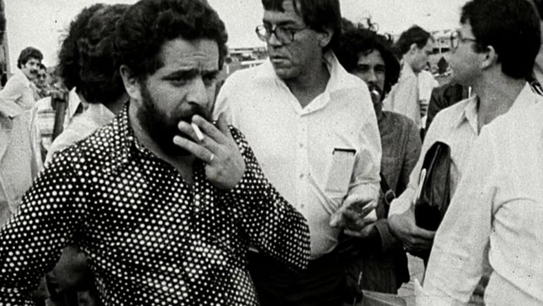 La imagen muestra a un joven Luiz Inácio Lula da Silva (de aproximadamente 33 años) fumando y vistiendo una camisa de lunares/bolitas durante las históricas huelgas de metalúrgicos del ABC Paulista en Brasil, en el año 1979.