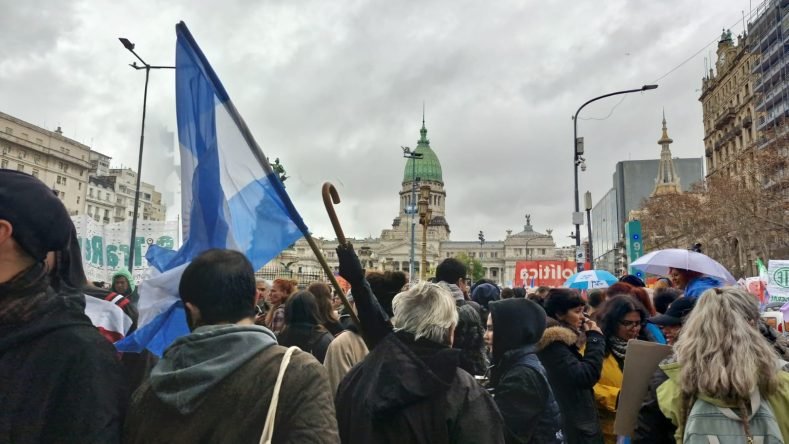 La imagen muestra una masiva movilización ciudadana y sindical frente al Palacio del Congreso de la Nación Argentina, ubicado en la Ciudad Autónoma de Buenos Aires.